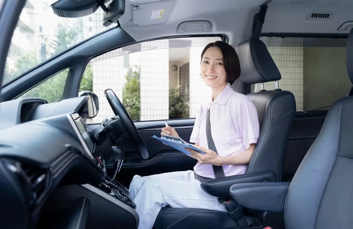 訪問先へ向かう車の中で、記録を確認する看護師